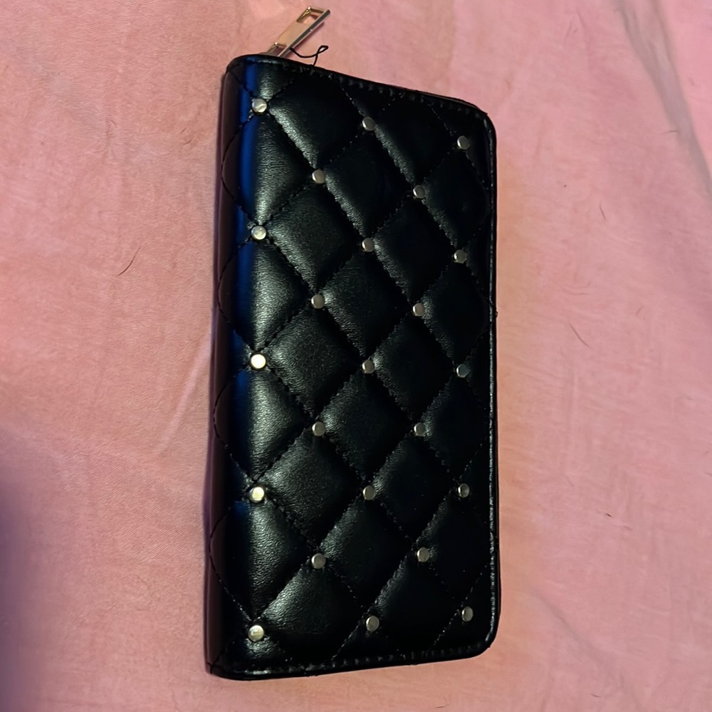 Black wallet with gold tacs.